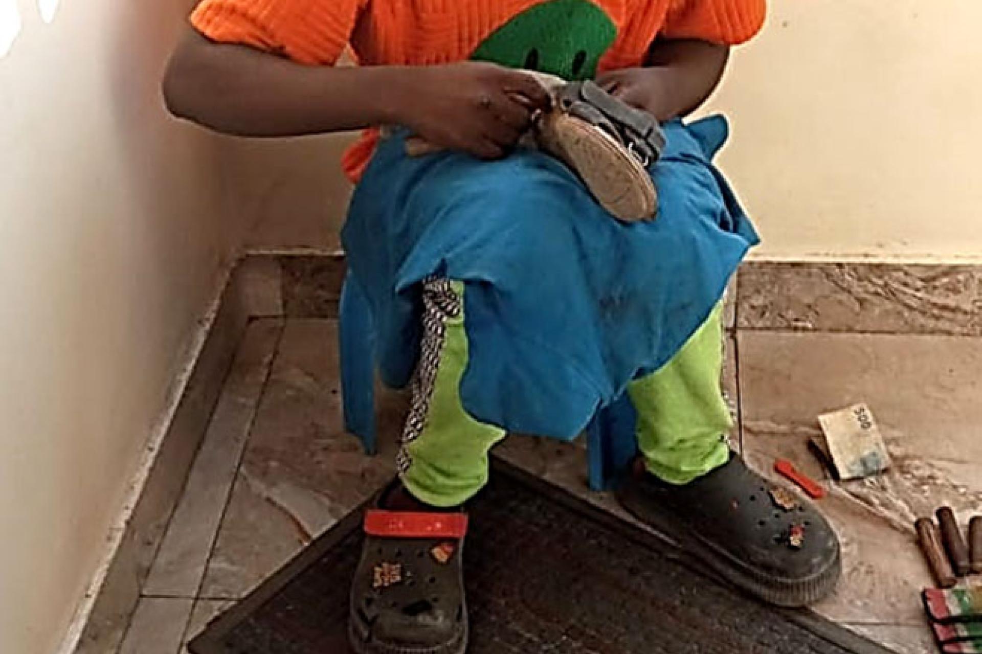 Moise-B.-en-train-de-reparer-les-chaussures-chez-lune-de-ses-clientes-non-loin-de-son-SG.-Photo-droits-tiers.jpg