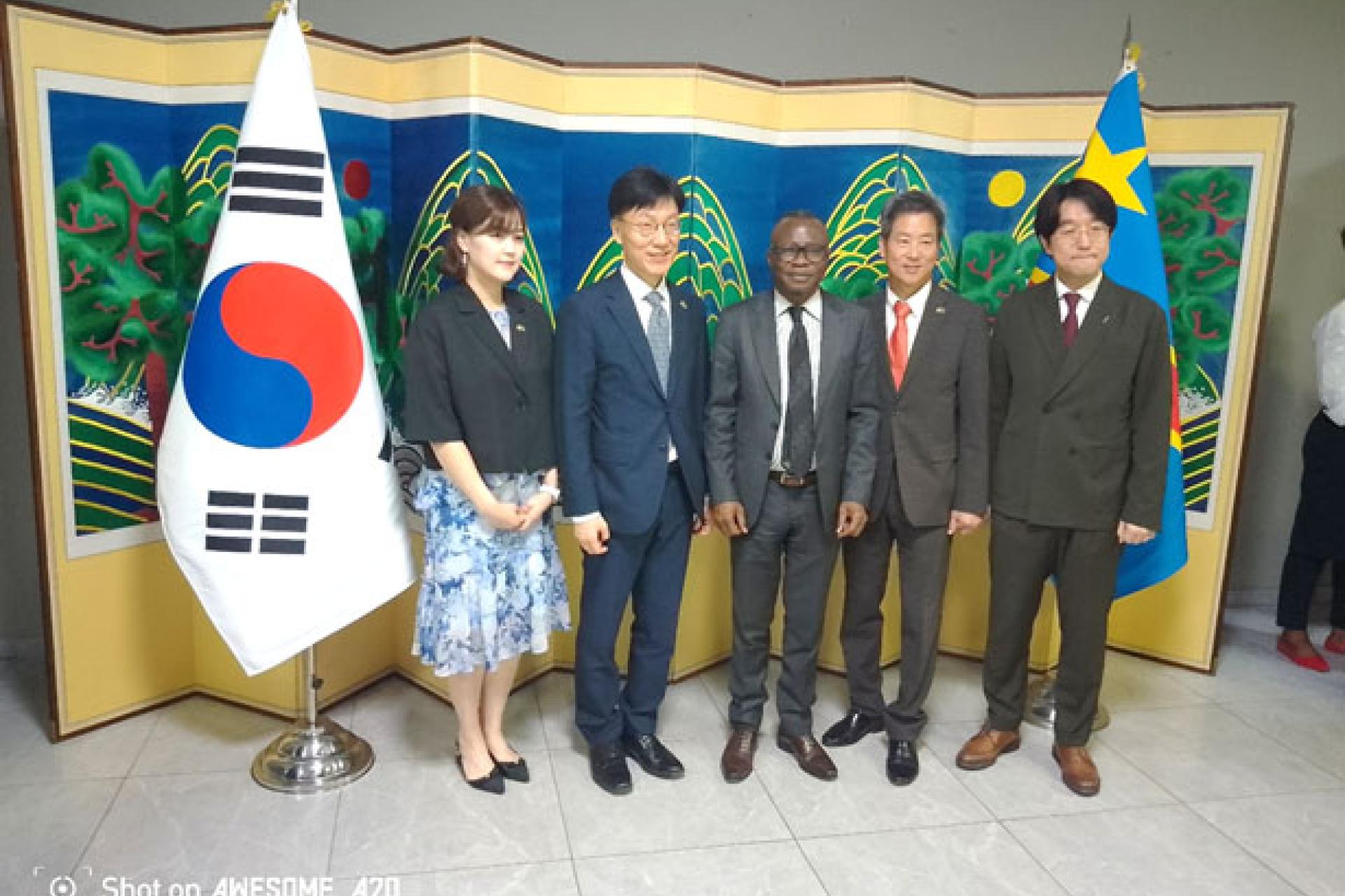 Posant-aux-cotes-de-ses-hotes-lambassadeur-Jeong-Hong-Geun-en-lunettes-de-Coree-du-Sud-immortalise-sa-toute-premiere-reception-de-la-fete-nationale-de-son-pays.-Photo-FDA.jpg