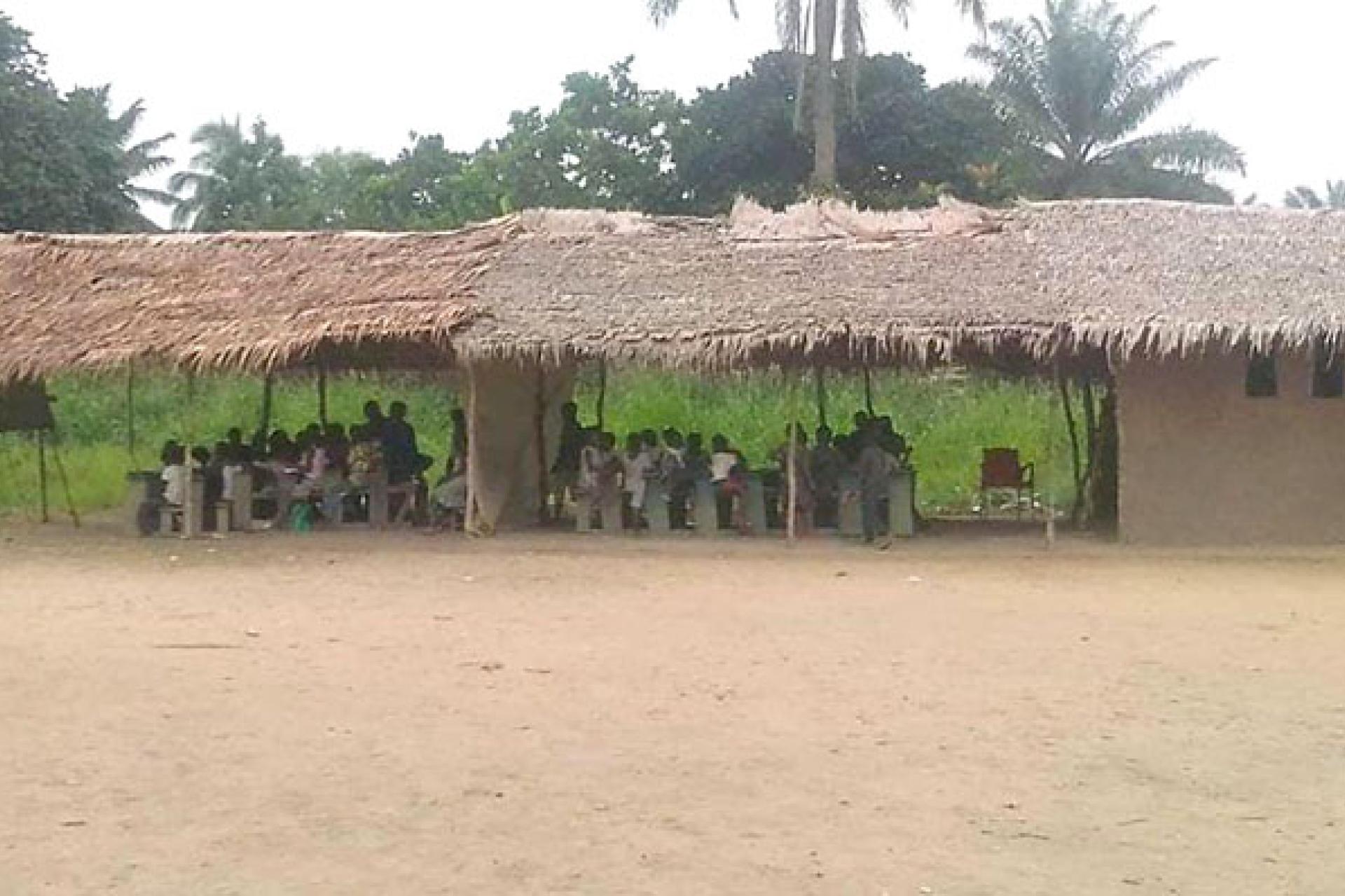 Une école improvisée sous un toit de chau